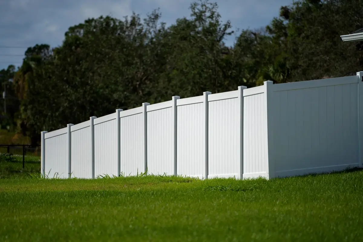 White vinyl picket fence on a green lawn