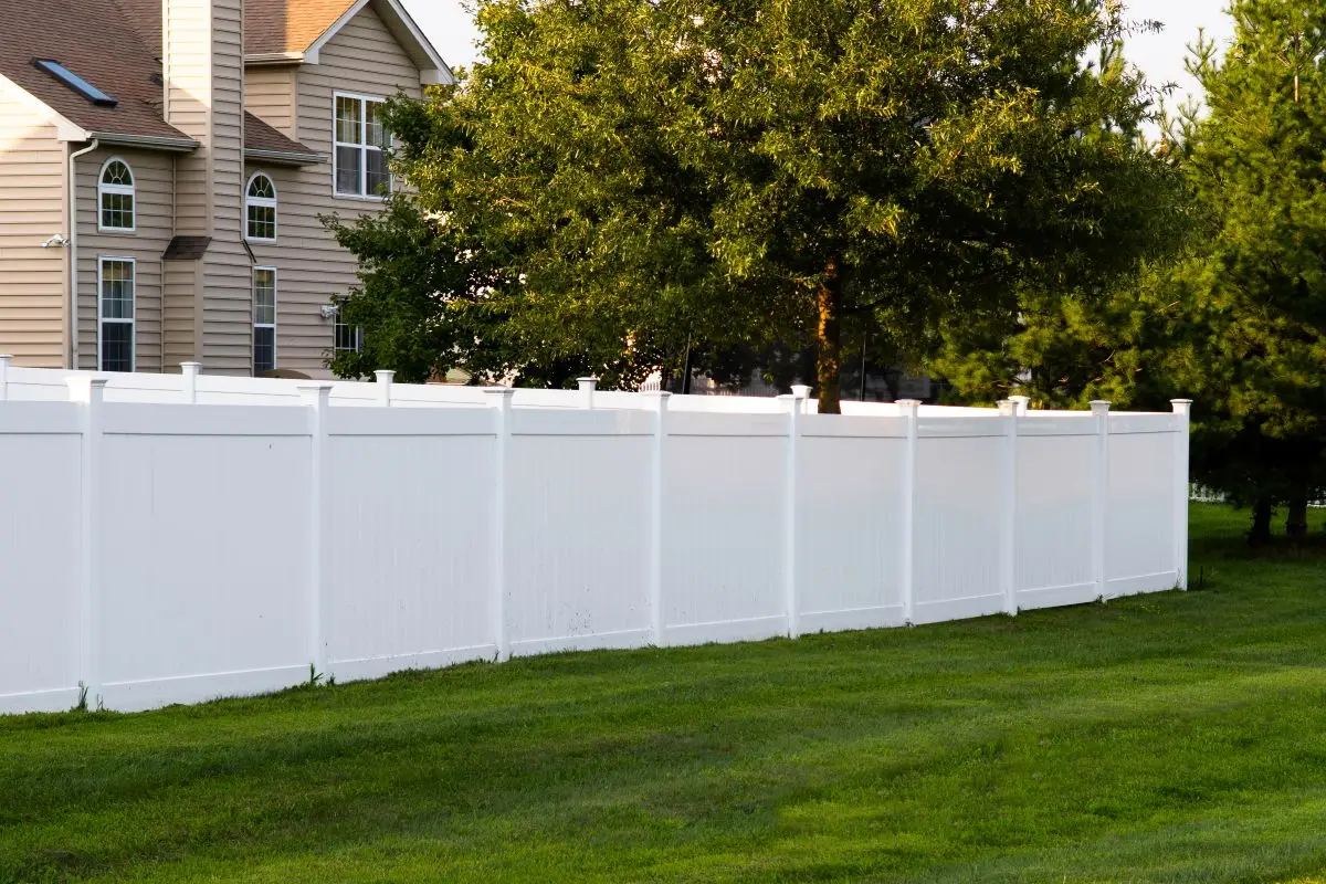 A newly installed white vinyl fence