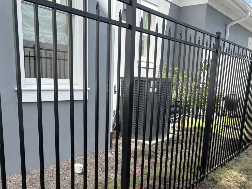 aluminum fence installation outside blue and white house