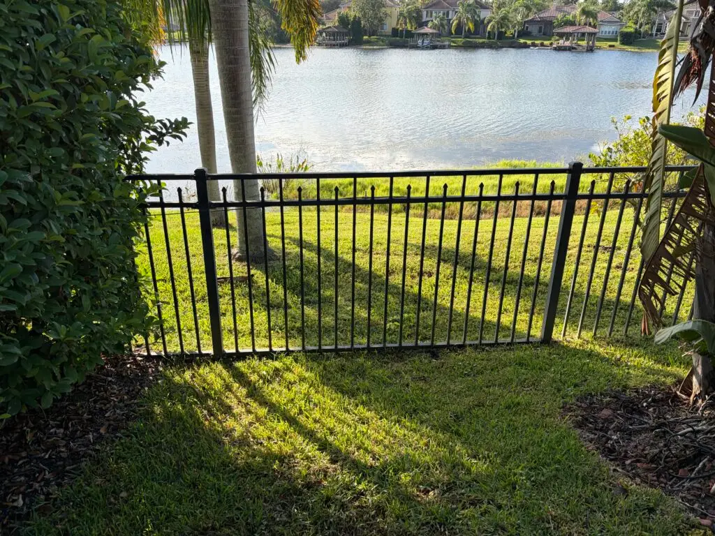 hoa approved fence black metallic fence lake behind