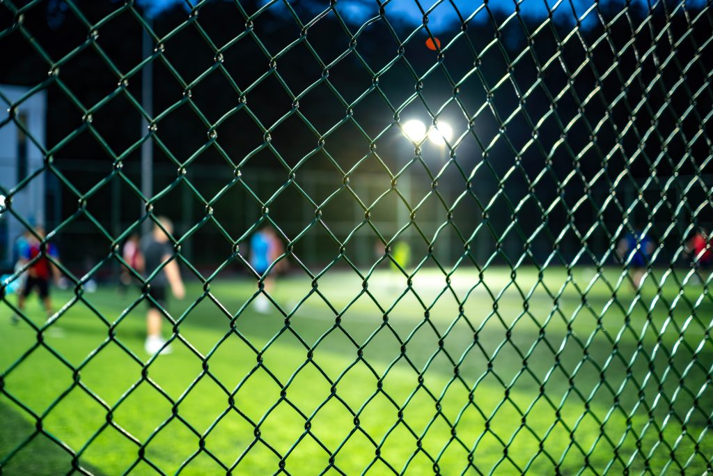 vinyl coated chain link fence People playing soccer behind a metal chain link fence at night","keywords_en":["people","playing","soccer","fence","chain link","night","sports","outdoor","grass","field","athletic","activity","recreation","game","players","illuminated","blurred","action","team","sport","leisure","evening","green","artificial","court","urban","fitness","exercising","group","motion","light","net","mesh","background","focus","sports venue","nighttime","outdoor activity"],"description_en":"Nighttime view of people playing soccer on a grass field behind a metal chain link fence with bright lights illuminating the area.
