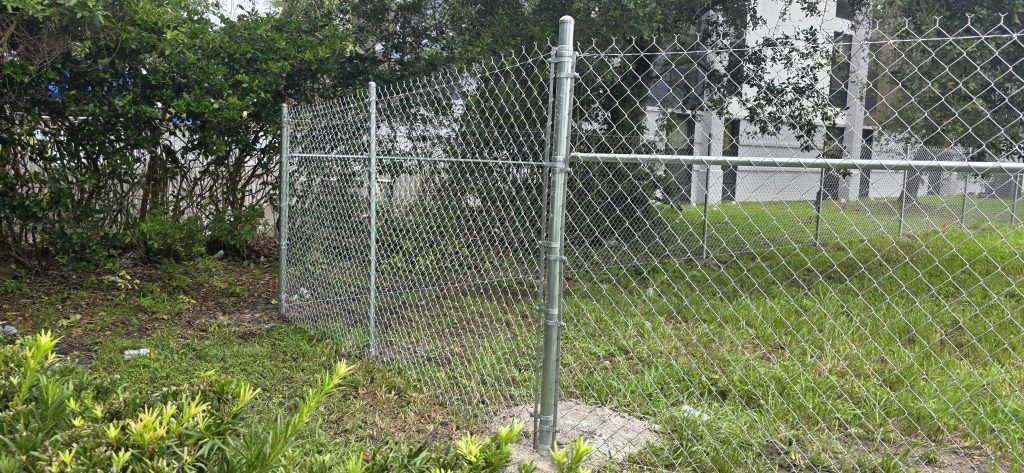 chain link fence replacement grey fence green field on the back