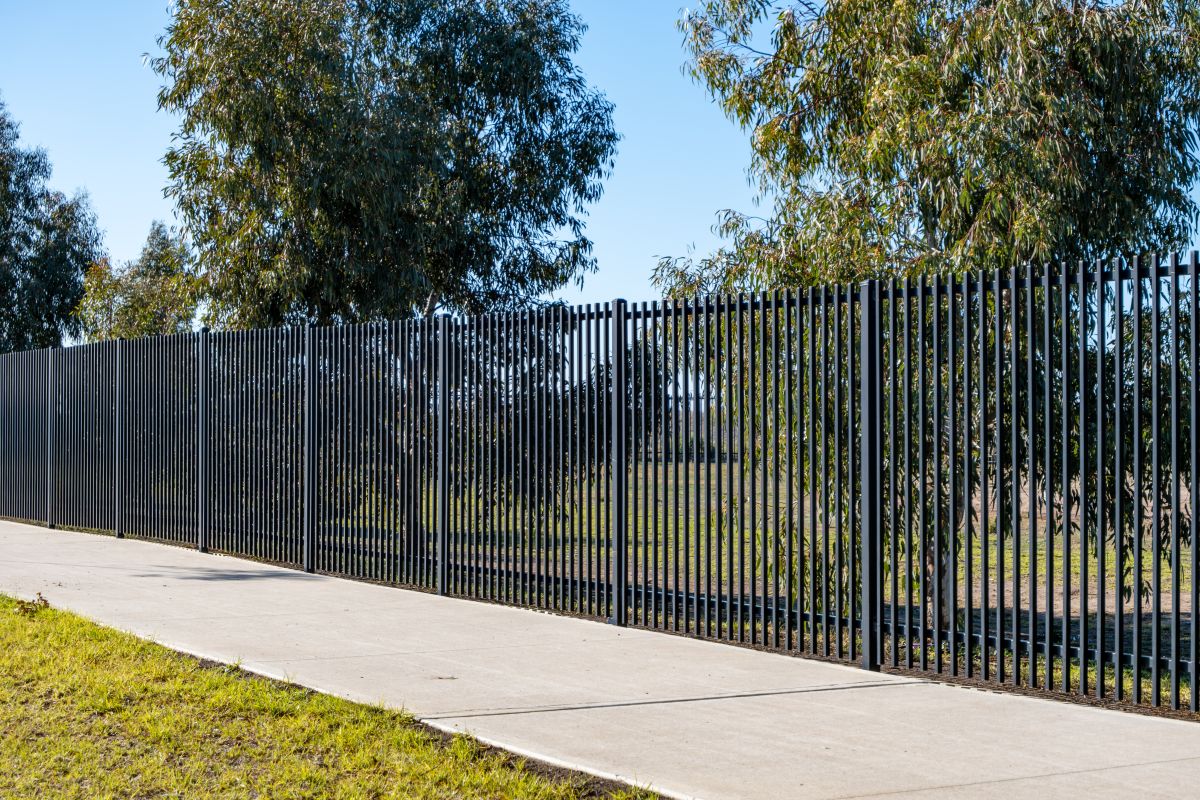 Tall black vertical metal fencing of a school campus