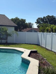A fence surrounding a yard with a pool